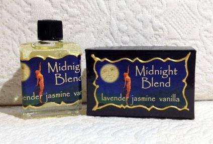 A bottle and bar of Seventh Muse Fragrant Oil - Midnight Blend soap scented with lavender, jasmine, and vanilla, displayed against a textured white background reminiscent of French perfume elegance.