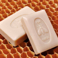 Two bars of La Lavande - Extra Fragrant Honey - 150 gm soap lying on a honeycomb patterned surface. The soaps, enriched with sweet almond oil, are embossed with an image of a bee and the word "vege".