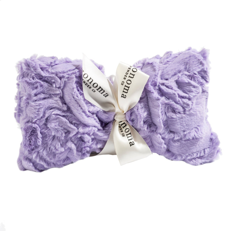 A soft, plush Sonoma Lavender Bellflower Rose Spa Mask neatly folded and tied with a white ribbon printed with the word "Sonoma Lavender", presented against a white background.