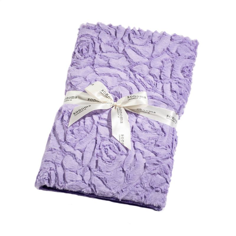 A Sonoma Lavender Bellflower Rose Spa Blankie, neatly folded and tied with an ivory ribbon labeled "Sonoma Lavender," isolated on a white background.