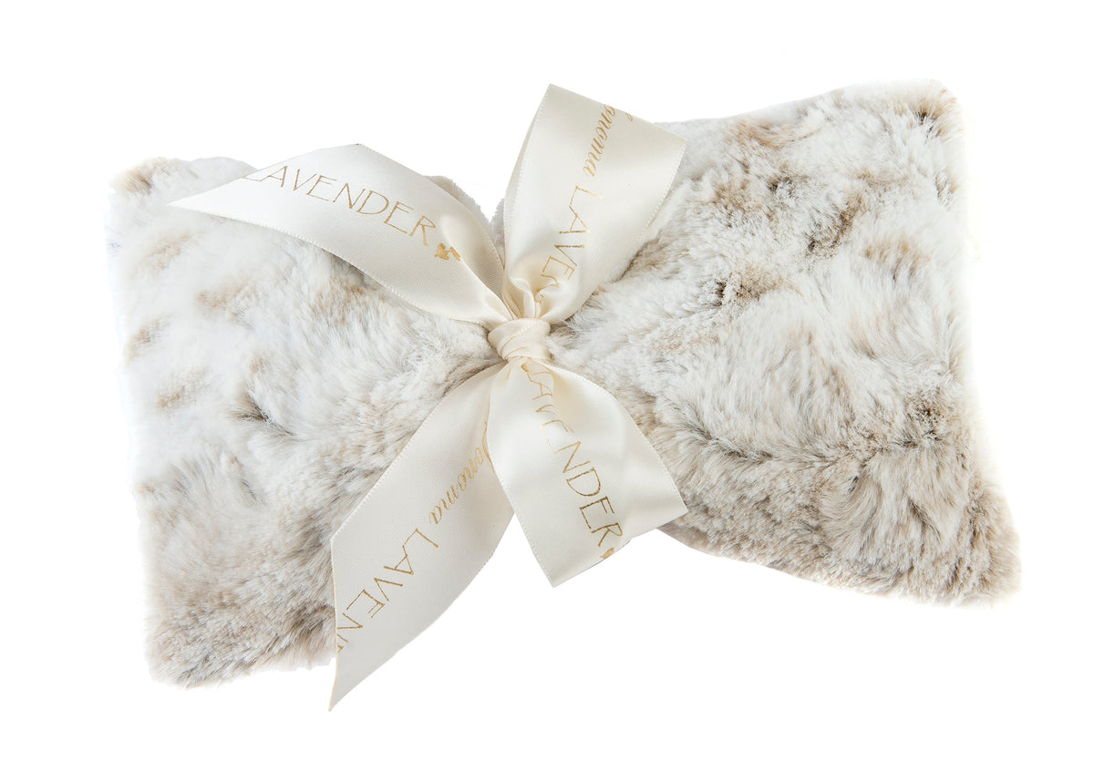 A fluffy, white Sonoma Lavender Arctic Circle Spa Mask tied with an elegant cream ribbon printed with the word "lavender flower" in gold, isolated on a white background.
