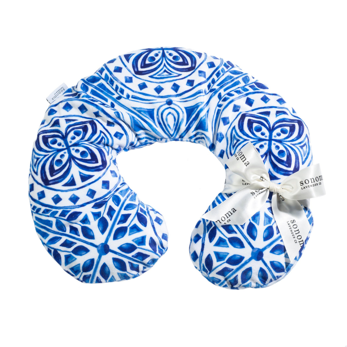 A Sonoma Lavender Sonoma OceanAire Santorini Mosaic neck pillow, designed in a u-shape with an OceanAire scent, features circular and geometric shapes and has visible brand tags attached.