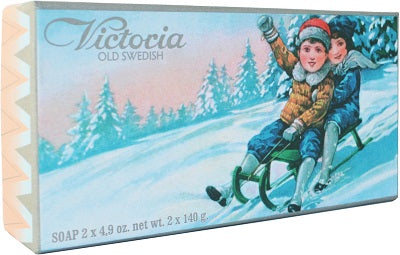 Vintage Victloria Scandinavian Soaps Swedish Christmas Soap box featuring an illustration of two children sledding in a snowy landscape, dressed in winter clothing. The box text reads "Victoria Old Swedish" and soap weight details.