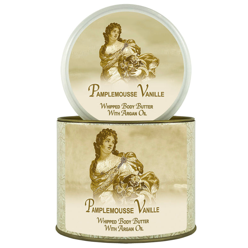 Two cylindrical containers of La Bouquetiere Pamplemousse (Grapefruit) Vanille Argan Oil Whipped Body Butter. The top one shows the open lid with a Victorian-style illustration of a woman, and the bottom one is