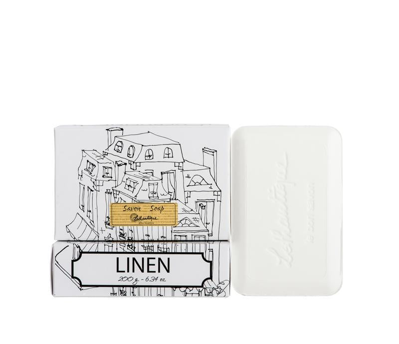 Two bars of Lothantique soap with packaging; one features a sketch of buildings titled "linen" and the other is a plain white French-milled soap bar, both isolated on a white background.