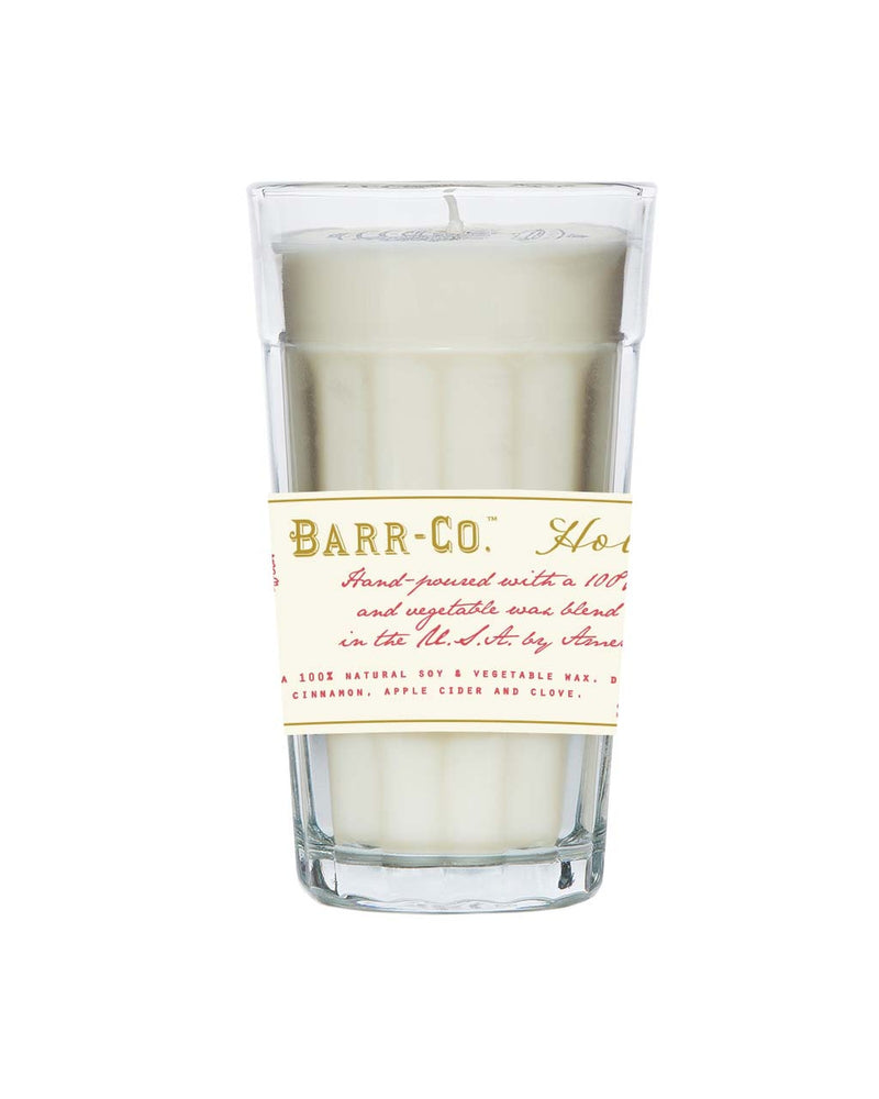 A Barr-Co. Holiday Parfait Glass Candle containing a hand-poured candle with a vintage-style label that describes its ingredients as natural soy and vegetable wax, scented with hints of cinnamon, apple cider, and clove.