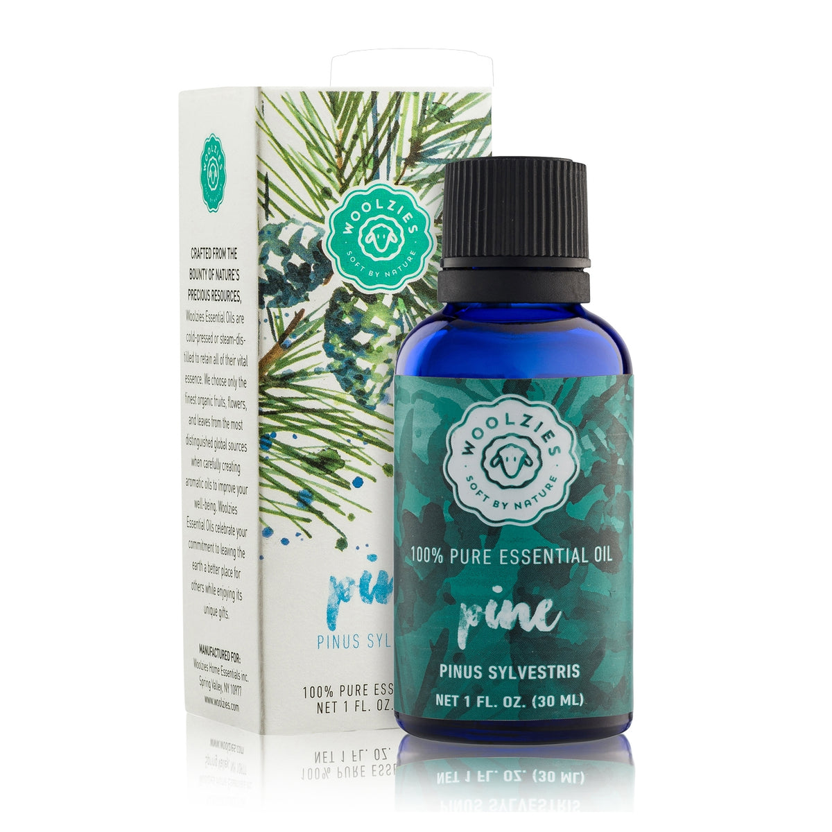 A bottle of Woolzies Pine Essential Oil, diffused with a dark blue label next to its packaging box decorated with green pine illustrations. The label and box display product information.