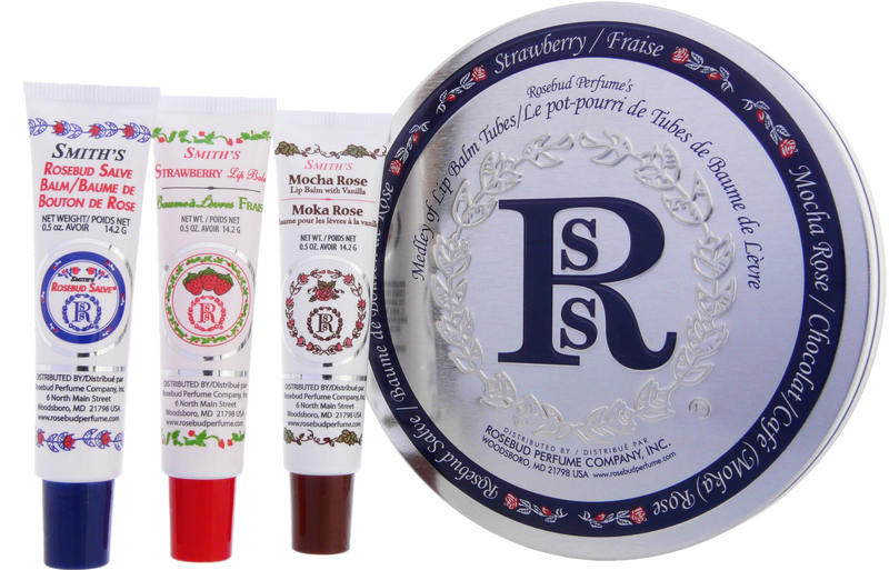 An arrangement of four Rosebud Perfume Co.'s Smith’s Medley of Lip Balm Tubes displayed in front of their circular tin package, featuring flavors including Rosebud Salve Tube and strawberry, mocha rose, and minted rose.