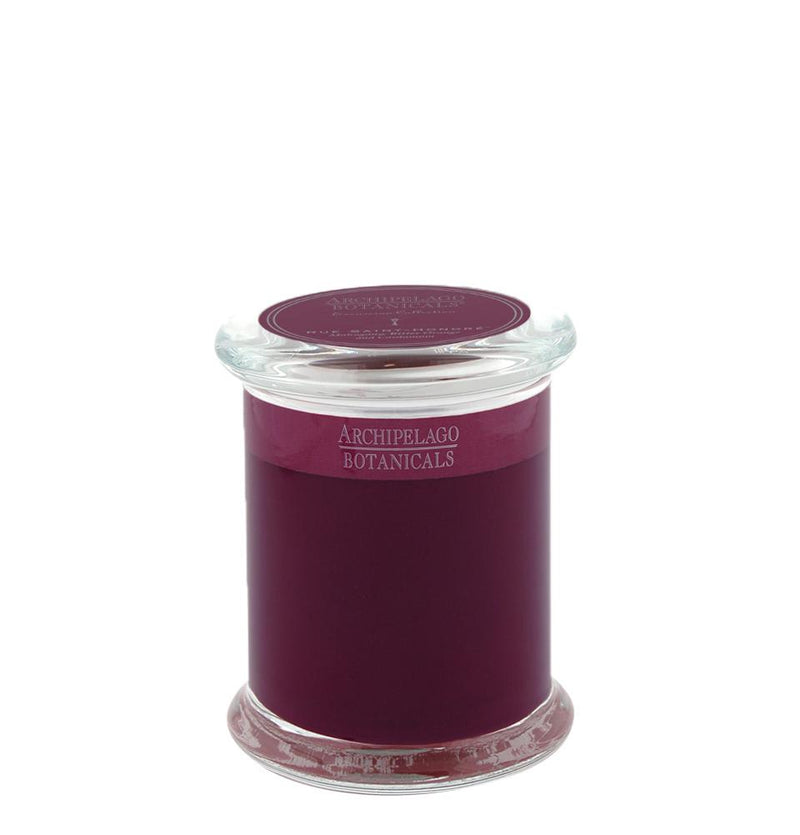 A jarred Archipelago Excursion Rue Saint-Honoré Glass Jar Candle with dark purple premium candle waxes, visible through clear glass, and topped with a clear glass lid, against a white background.
