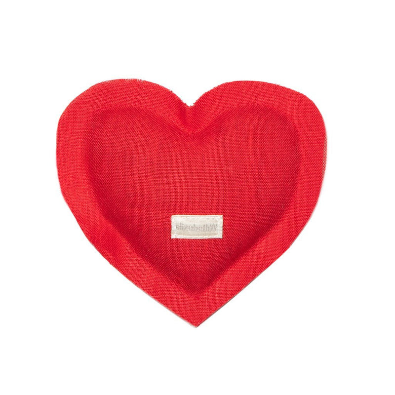 A red fabric Elizabeth W Linen Heart Sachet with a visible tag on the lower part, isolated on a white background, infused with a herbal aroma.