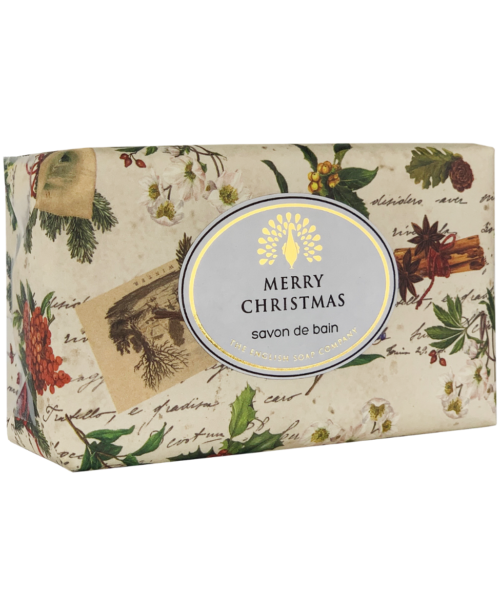 A bar of The English Soap Co. Christmas Robin & Holly Vintage Italian Wrapped Soap wrapped in vintage-style Christmas-themed paper, featuring illustrations of pinecones, mistletoe, and berries, with a label that reads "Merry Christmas" in