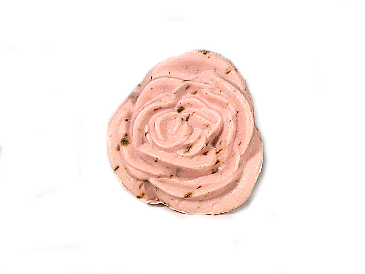 A single, beautifully piped rose made of pink frosting with flecks of vanilla bean, resembling a sculpted wild rose, isolated on a white background is like the La Lavande Flower Soap - Rose Petal from La Lavande.