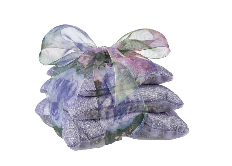 A stack of Sonoma Lavender Sachet Trios - Lilac Dupioni tied with a sheer, colorful ribbon, isolated on a white background.