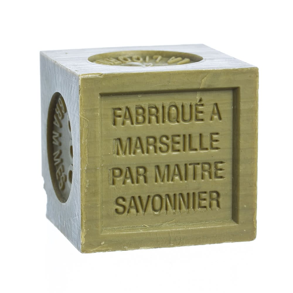 A fragrance-free, cube-shaped, green French Soaps Hard Milled Savon de Marseille with the text "fabriqué à Marseille par maître savonnier" embossed on it, isolated on a white background.