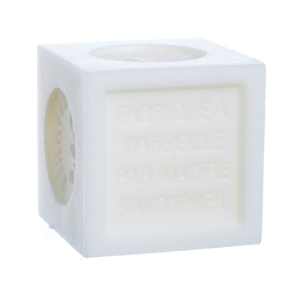 A translucent white jasmine soap cube with text embossed on one side that reads "fabriqué à marseille par maître savonnier", isolated on a white background is the French Soaps Savon de Marseille with Crushed Flowers - Jasmine by French Soaps.