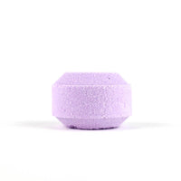 A single Spinster Sisters Lavender Shower Steamer infused with lavender essential oil, isolated against a white background, displaying its textured surface.