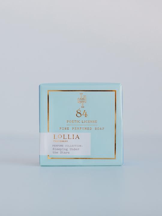 A light blue box of Margot Elena brand triple-milled soap labeled "Lollia Poetic License Sleeping Under the Stars Wrapped Bar Soap", part of the "Sleeping Under the Stars Collection." The box features elegant white and gold text.