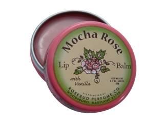 A round tin of Smith's Rosebud Mocha Rose Lip Balm with Vanilla from Rosebud Perfume Co. with a vintage-style label featuring a flower illustration and text that includes "with essential oils." The tin is partially opened to reveal the product inside.