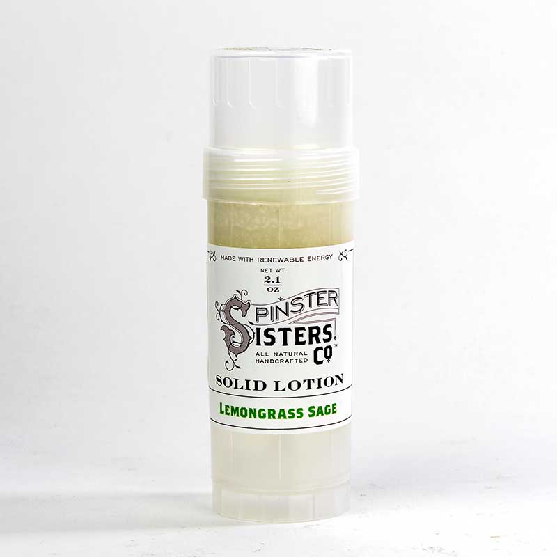 A container of Spinster Sisters Co. solid lotion in lemongrass sage scent, enriched with Fair Trade shea butter, with a label indicating it's made with renewable energy, displayed against a