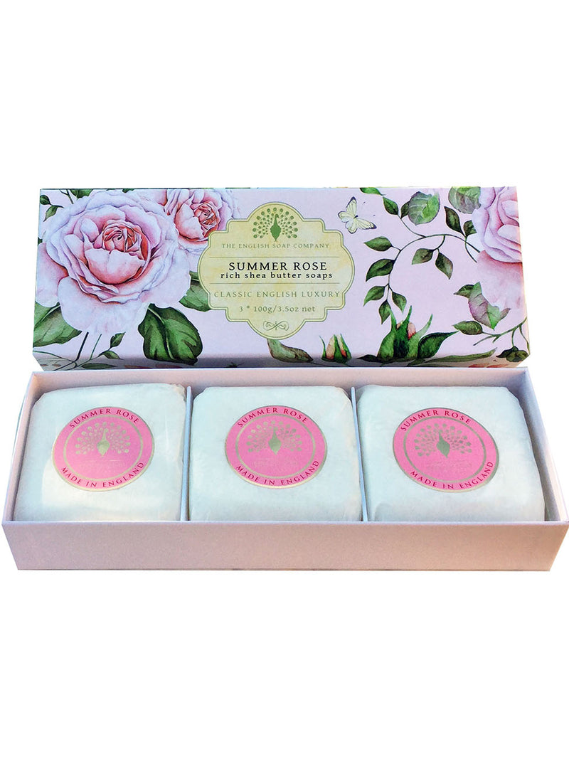 A decorative box containing three circular, triple-milled soaps, each wrapped in paper with a floral design. The box lid features intricate illustrations of pink roses and the text "The English Soap Co.