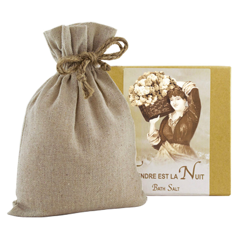 A La Bouquetiere Tendre est la Nuit Bath Salts with Linen Bag next to a vintage-style bath salt box featuring an image of a woman holding a basket of flowers. The text on the box is in French and advertises Mediterranean Sea Salts.