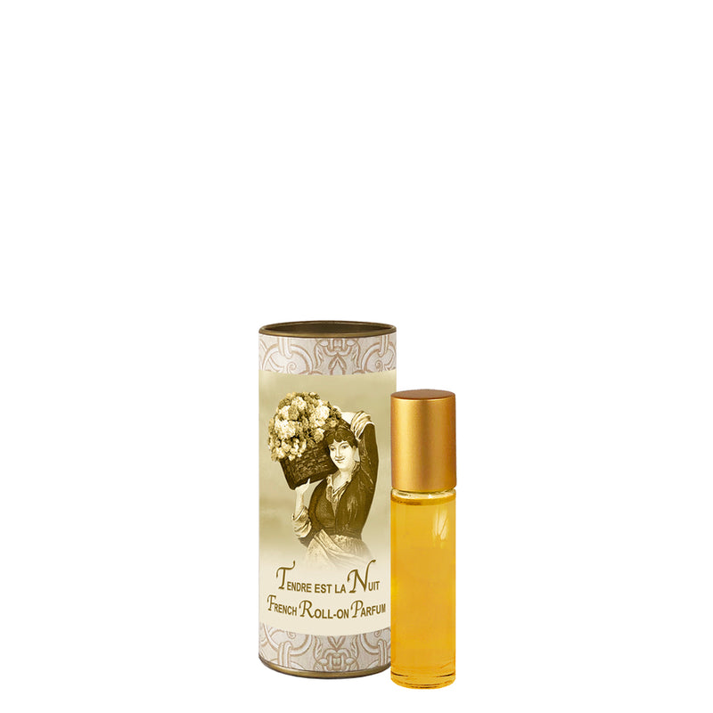 A La Bouquetiere Tendre est la Nuit perfume roller alongside its cylindrical, decorative packaging, featuring a vintage floral design and a portrait of a woman with early 20th-century French attire.