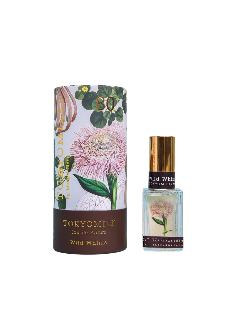 A TokyoMilk Wild Whims No. 80 Parfum bottle and its packaging. The bottle carries a floral design label with hints of clary sage. The cylindrical box features a detailed botanical illustration with the brand "Margot Elena" prominently displayed.