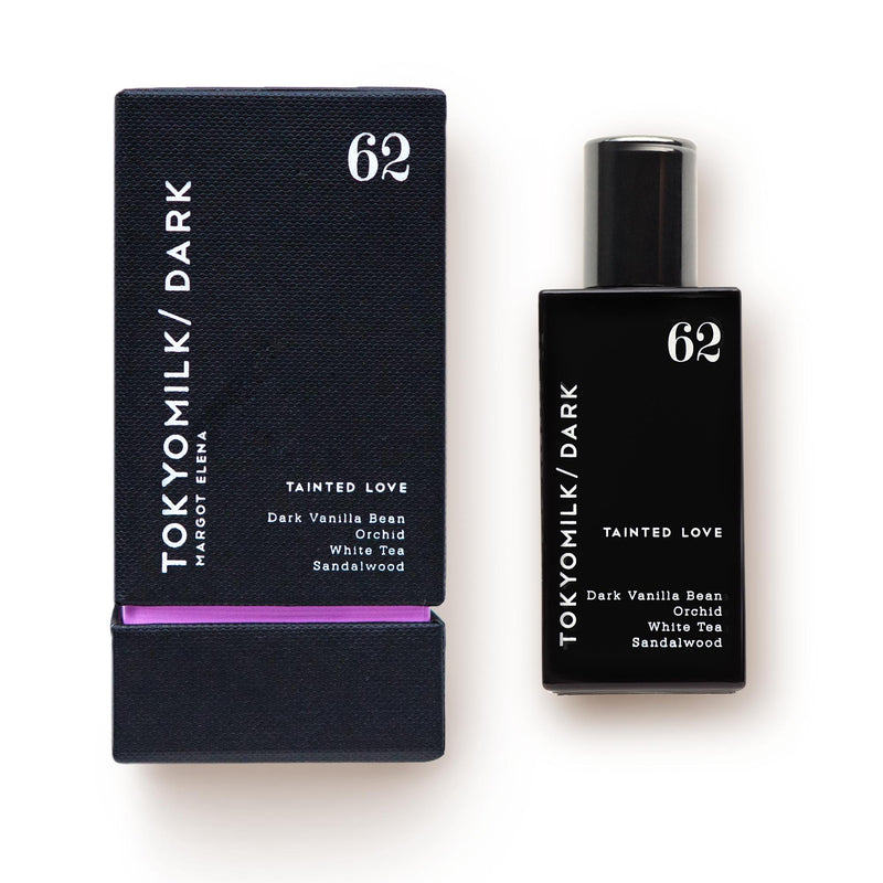 A black Margot Elena TokyoMilk Dark Tainted Love No. 62 Eau de Parfum bottle labeled with dark vanilla bean, white tea, and sandalwood, next to its corresponding black and purple packaging.