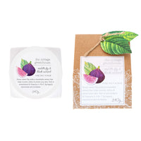 Two packaged skin care products, one in a white container labeled "Violette Fig & Black Currant Fine Salt Scrub" from Margot Elena, and another in a brown packaging with a leaf, labeled "Pomegranate & Black Currant" from Margot Elena.