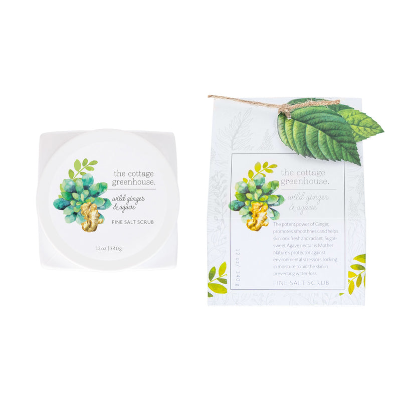 A square product packaging featuring a Wild Ginger & Agave Fine Salt Scrub from Margot Elena with a botanical theme, displaying leaves and flowers on both the container and the box.