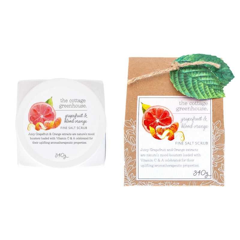 Two packages of the Margot Elena Cottage Greenhouse Grapefruit & Blood Orange Fine Salt Scrub: on the left, a square white container labeled grapefruit & blood orange fine salt scrub with apricot kernel oil; on the right, a craft paper package with
