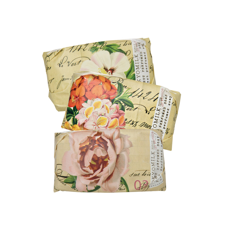 Three decorative gift boxes stacked, each adorned with vintage floral prints and script calligraphy, containing Margot Elena's TokyoMilk Botanica Mini Soap Collection N0. 3, isolated on a white background.