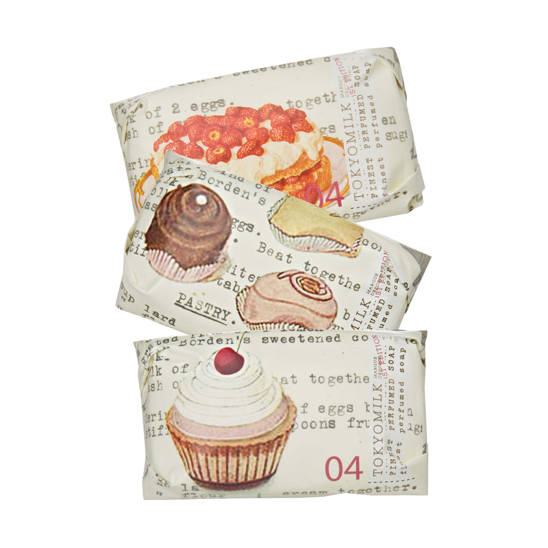 Three stacked bars of TokyoMilk Just Desserts Mini Soap Collection wrapped in decorative paper featuring vintage-style illustrations of pastries and desserts, with visible text and numbers by Margot Elena.