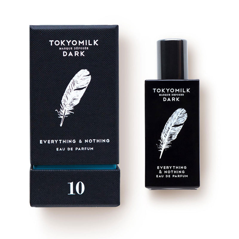 A bottle of Margot Elena's TokyoMilk Dark Everything & Nothing No. 10 Eau de Parfum perfume next to its packaging box. The items are black with white text and pressed petals designs, labeled with the number 10.