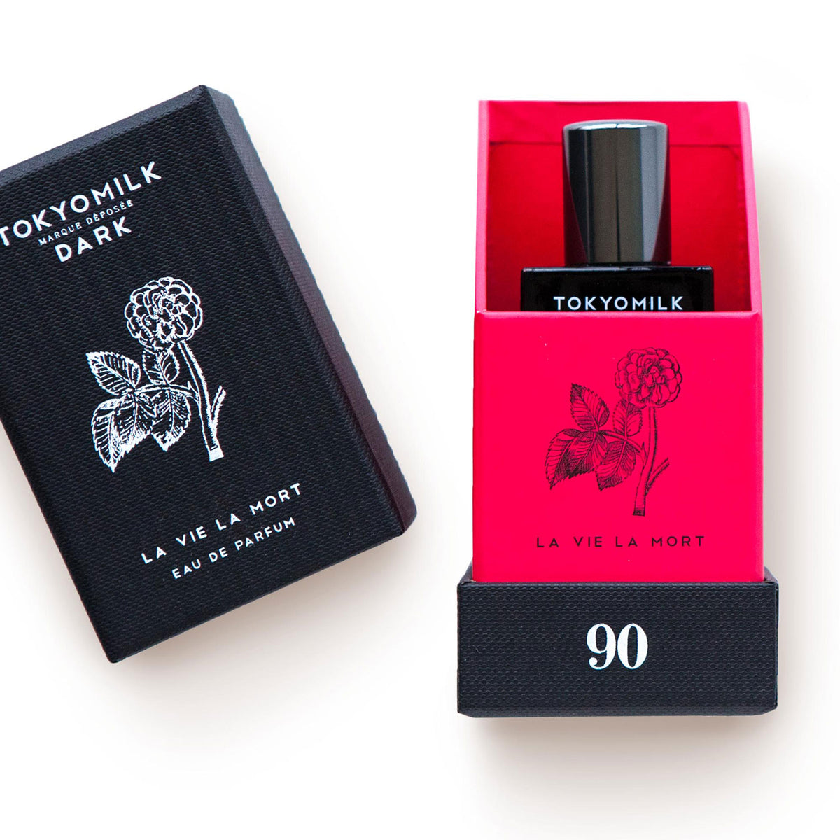 Margot Elena's TokyoMilk Dark La Vie La Mort No. 90 Eau de Parfum perfume with a black box featuring a white jasmine and tuberose floral design on the left, and a bright red perfume bottle labeled “la vie la mort” on the right