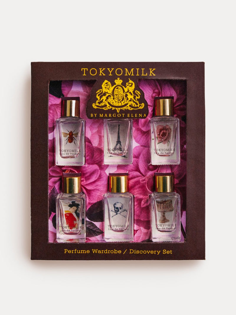 A TokyoMilk Classic EDP Discovery Set by Margot Elena, featuring six classic dabbers with various designs, displayed against a floral pink background, encased in a dark brown box.
