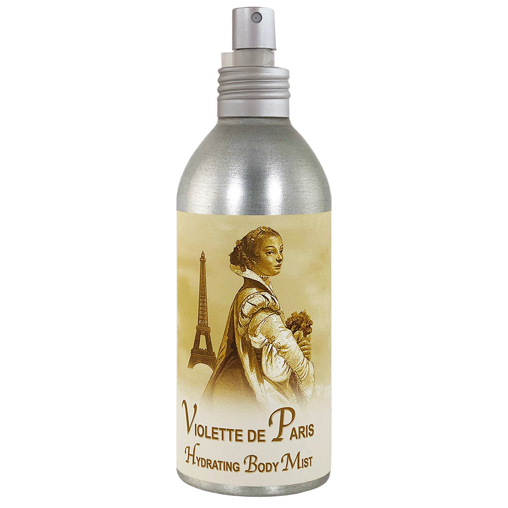 A metallic bottle of La Bouquetiere Violette de Paris moisturizing body mist with a vintage-style label featuring an illustration of a woman in period attire and the Eiffel Tower.