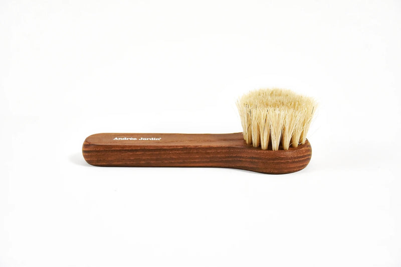 A Andreé Jardin Heritage Face Cleansing Brush Heat-Treated Ash Wood with natural bristles on a white background. The handle is engraved with the text "Andrée Jardin.
