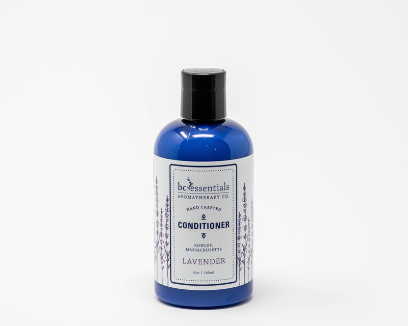 A blue bottle of BC Essentials Lavender Hair Conditioner with a black cap on a white background. The label mentions it’s hand-crafted, lavender-scented, and from Beverly, Massachusetts.