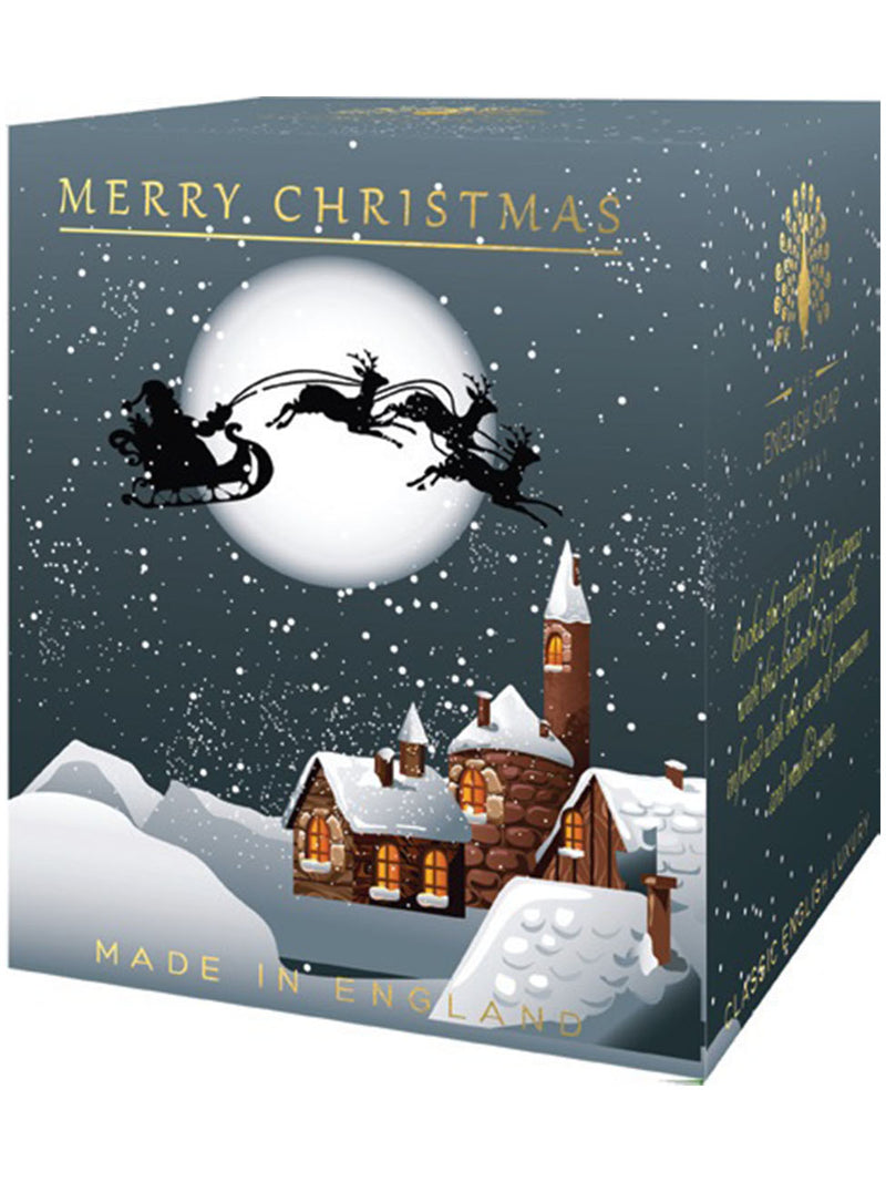 Illustration of The English Soap Co. Winter Village Pure Soy Candle box featuring Santa Claus on a sleigh and reindeer flying over a snowy village under a full moon, with "Merry Christmas" and festive designs, infused with mul