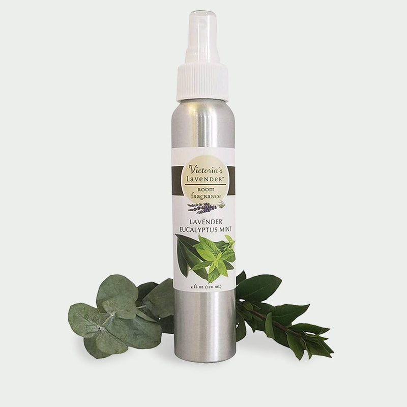 A spray bottle labeled "Victoria's Lavender - Lavender Eucalyptus Mint Room Spray" on a white background, flanked by green eucalyptus leaves.