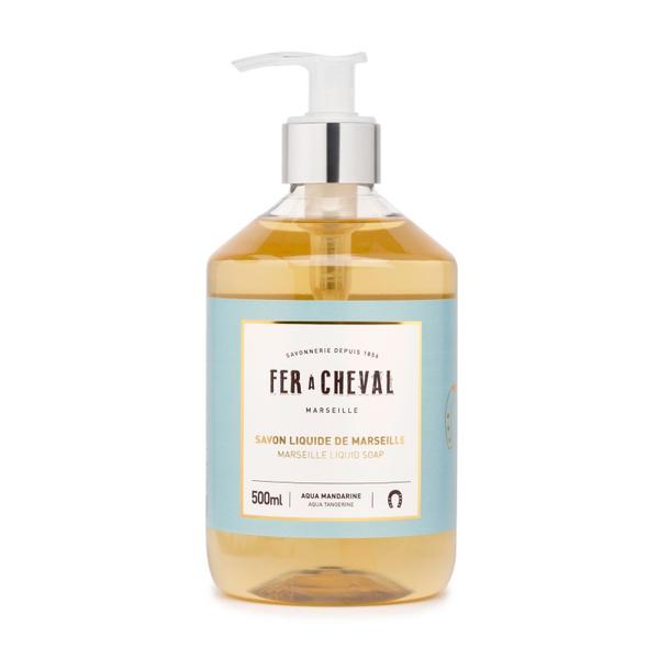 A 500ml transparent pump bottle of Fer à Cheval Marseille liquid soap with natural origin ingredients, featuring a clear amber color and a label with blue and white text.