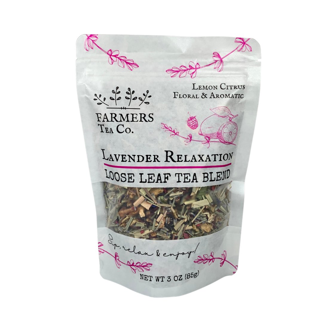 A package of FARMERS Lavender Co. Lavender Relaxation Tea, featuring lemon citrus flavors and rich in antioxidants, labeled and visible through a clear window, decorated with pink floral accents.