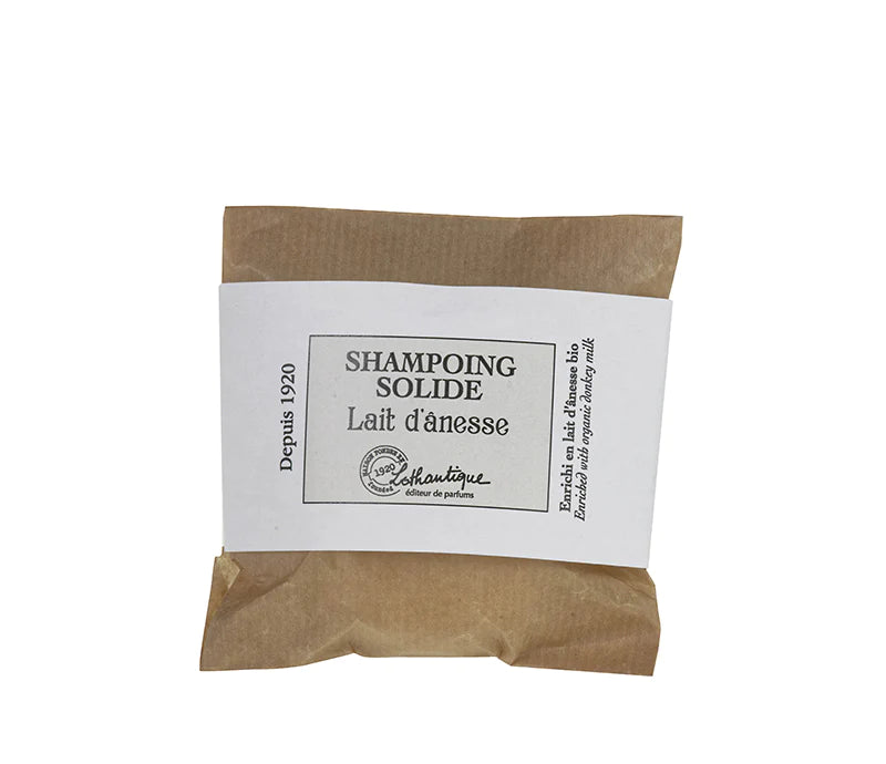 A Lothantique 75g Solid Shampoo Donkey Milk wrapped in brown paper with a white label reading "shampoing solide lait d'ânesse," indicating it is made with donkey milk.