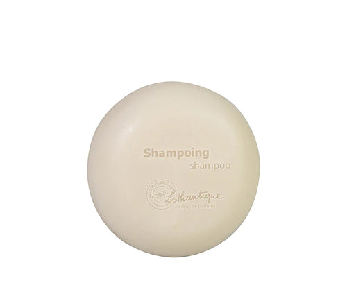 A Lothantique 75g Solid Shampoo Donkey Milk with the embossed text "shampooing shampoo" and "lush boutique - éthique et partenaires" on a plain, light background.