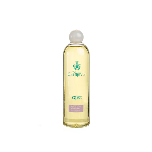 A clear 500ml Carthusia I Profumi de Capri Fiori di Capri Reed Diffuser Refill bottle with a round cap and yellow liquid stands upright against a white background, its label featuring green and purple text and evoking a Mediterranean fragrance.