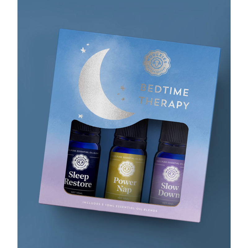 Packaging of the "Woolzies The Bedtime Therapy Collection" essential oil set featuring three bottles labeled "sleep restore," "power nap," and "slow down" against a blue backdrop with a moon graphic, formulated to