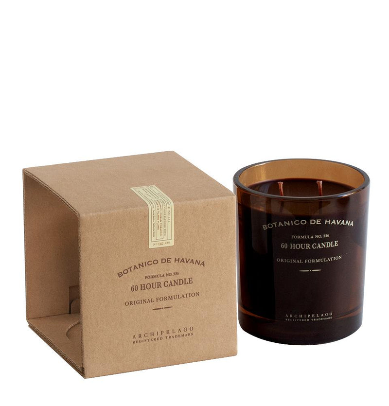 A brown cardboard box labeled "Archipelago Botanico de Havana Glass Boxed Candle" with hints of Tobacco Flower, next to a dark glass candle labeled with the same branding, against a white background.
