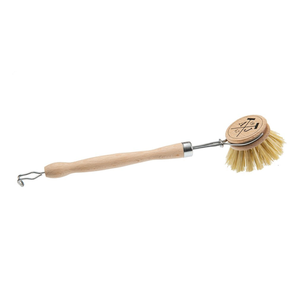 A Andrée Jardin Tradition Handled Dish Brush with natural bristles and a metal loop at the end for hanging, made in France, featuring an engraved logo on the wooden handle.