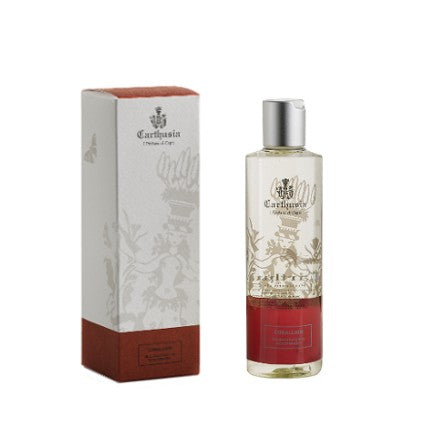 A Carthusia I Profumi de Capri Corallium Shower Gel bottle next to its packaging box. The bottle has a clear top half and a red bottom half with a decorative label featuring a crest and floral designs made from natural extracts.
